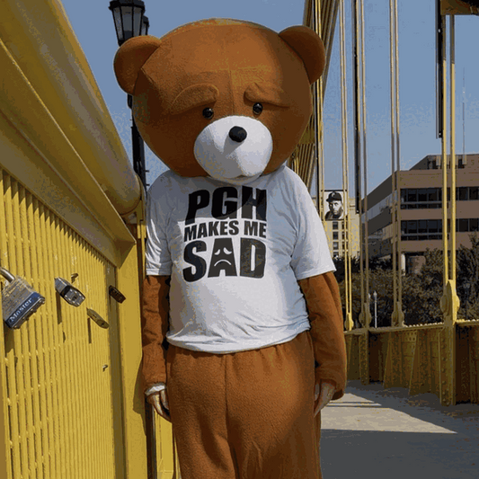Sad Bear wearing the white PGH Makes Me Sad T-shirt on a Pittsburgh bridge